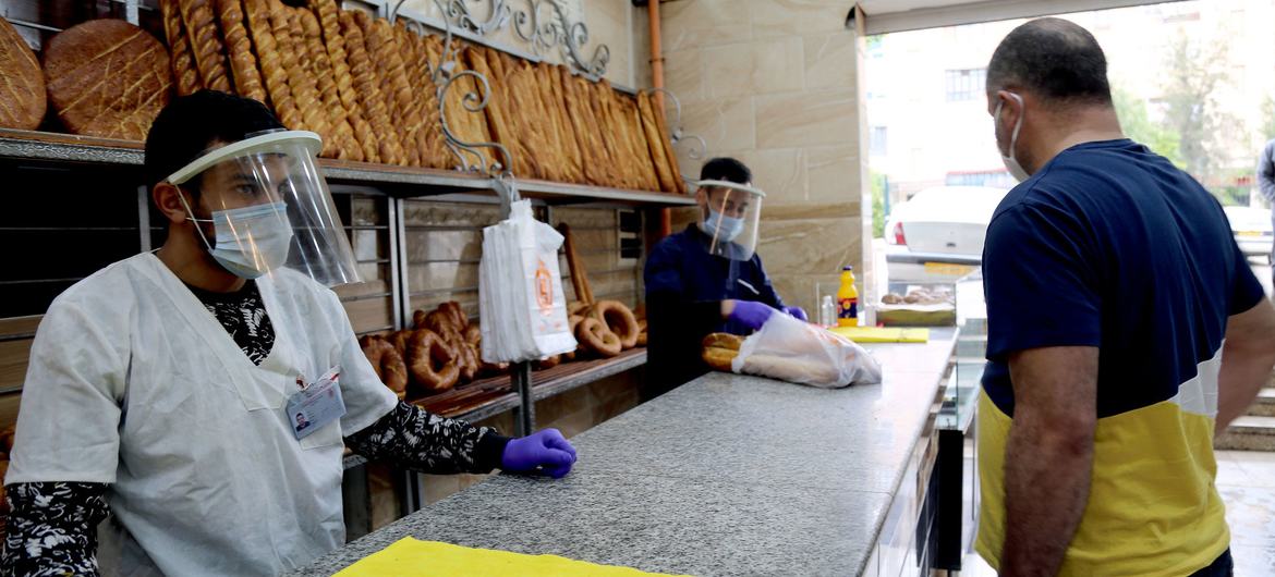 کارگران مغازه در یک نانوایی در کنستانتین، الجزایر در طول همه گیری کووید-19، نان می فروشند.